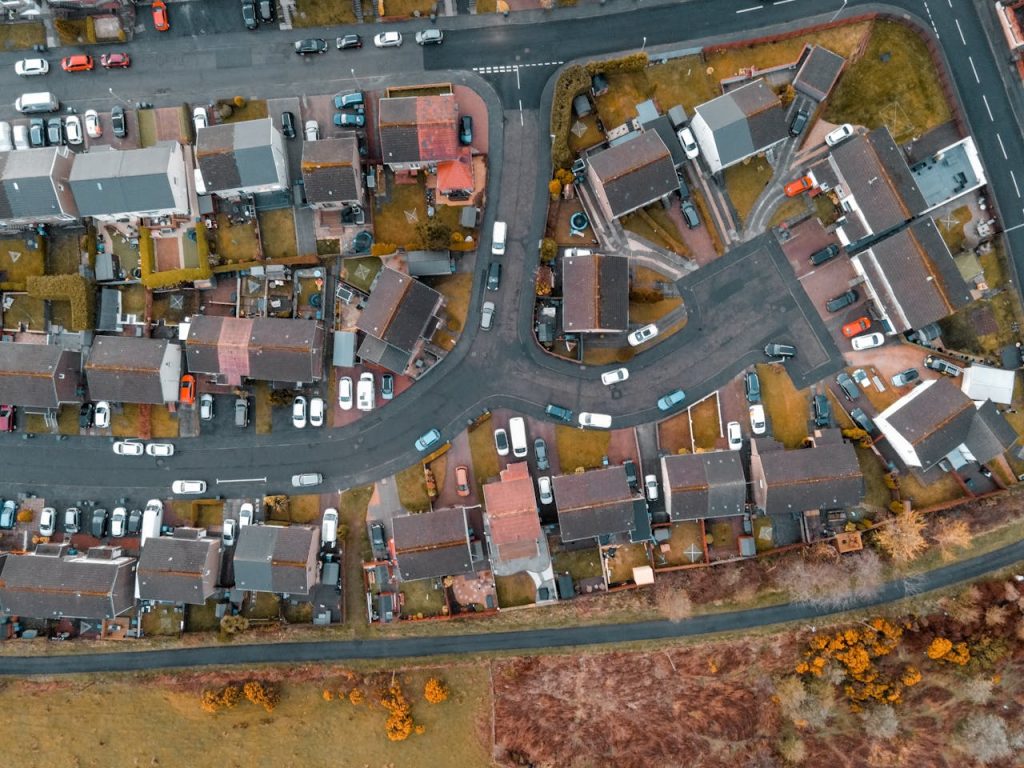 A top-down aerial shot capturing a suburban neighborhood in Scotland, showcasing houses and streets.